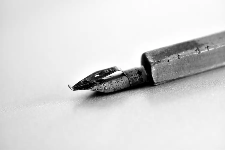 A worn steel dip-pen nib on a wooden holder